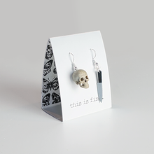 One skull shaped 3D printed earring with a small 3D printed knife