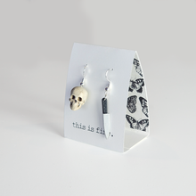 One skull shaped 3D printed earring with a small 3D printed knife