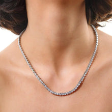 Close-up of a silver tennis necklace on a person's neck