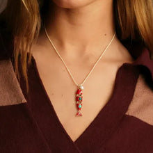 Necklace with a red pendant worn by a person