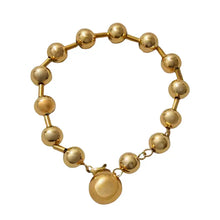 Gold beaded bracelet on a white background